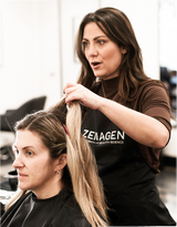 stylist in a salon working on client's hair wearing a Zenagen salon cape
