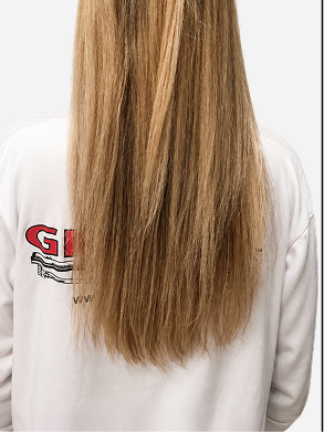 Back view of long blonde hair showing uneven texture, flyaways, and dry-looking ends before using Zenagen smoothing and conditioning hair care.