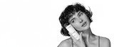 Woman holding Zenagen Revolve Women’s Shampoo for thinning hair, promoting volume, scalp health, and stronger-looking hair.