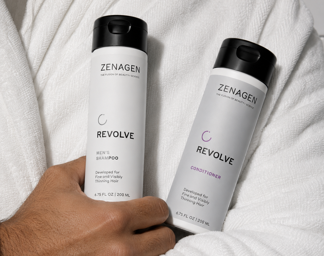 Zenagen Revolve shampoo and conditioner for fine and visibly thinning hair displayed on a white robe, featuring men's shampoo and conditioner bottles.